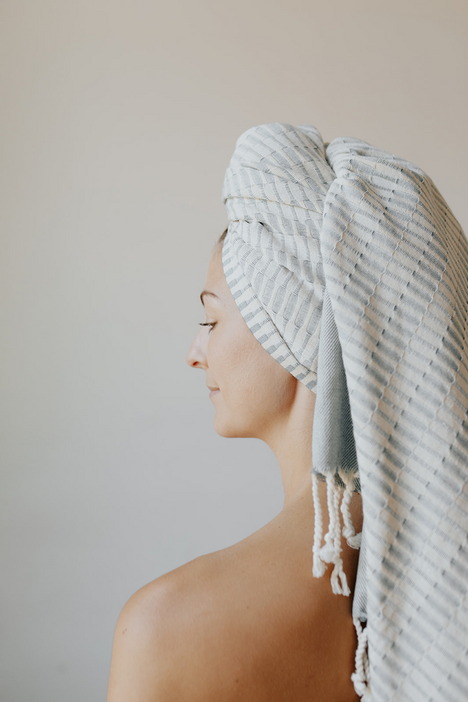 Woman using the Raised Weave Turkish Towel in Teal as a head wrap