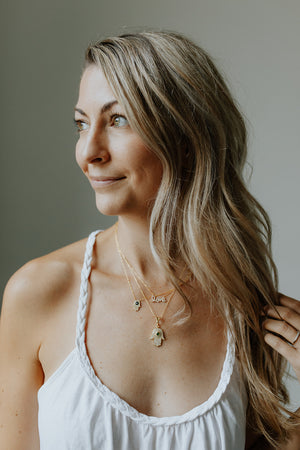 
            
                Load image into Gallery viewer, Woman wearing the Love Layering Necklace paired with the Hamsa + Evil Eye Necklaces
            
        