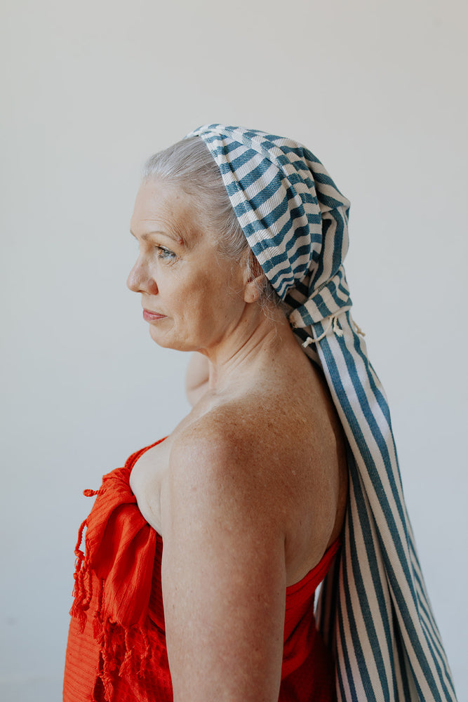 
            
                Load image into Gallery viewer, Stripe Turkish Towel in Teal being used as a head wrap
            
        