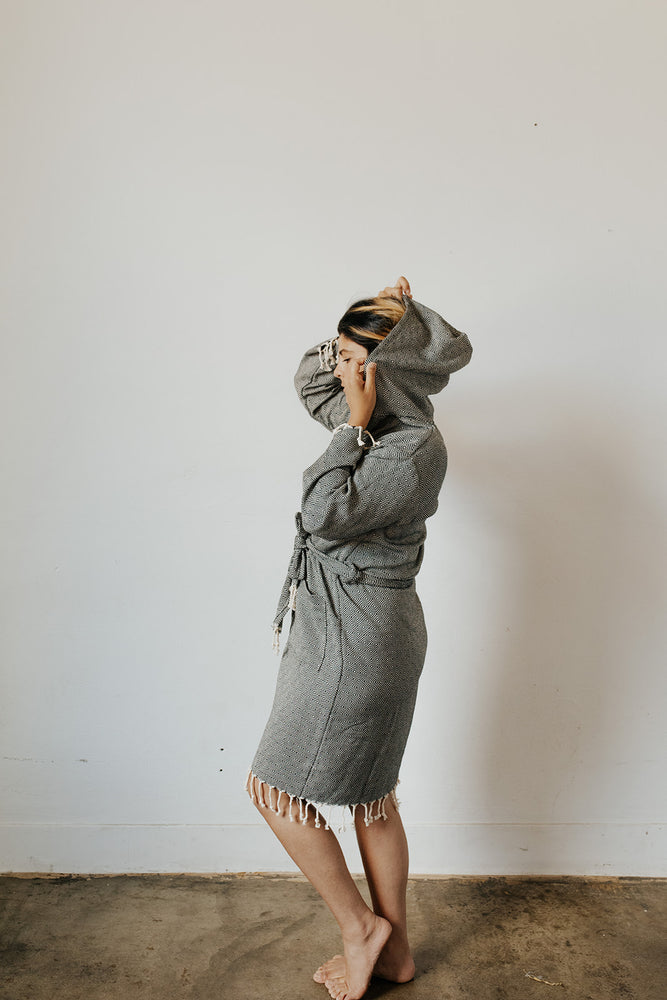 Woman wearing the Diamond Bathrobe in Charcoal with the hood up