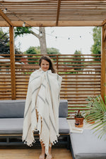 Woman wrapped in the Ribbon Stripe Blanket in Pearl