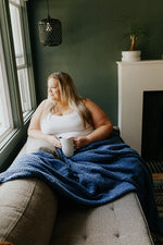 Woman drinking coffee with her Grid Pattern Blanket in Lapis 